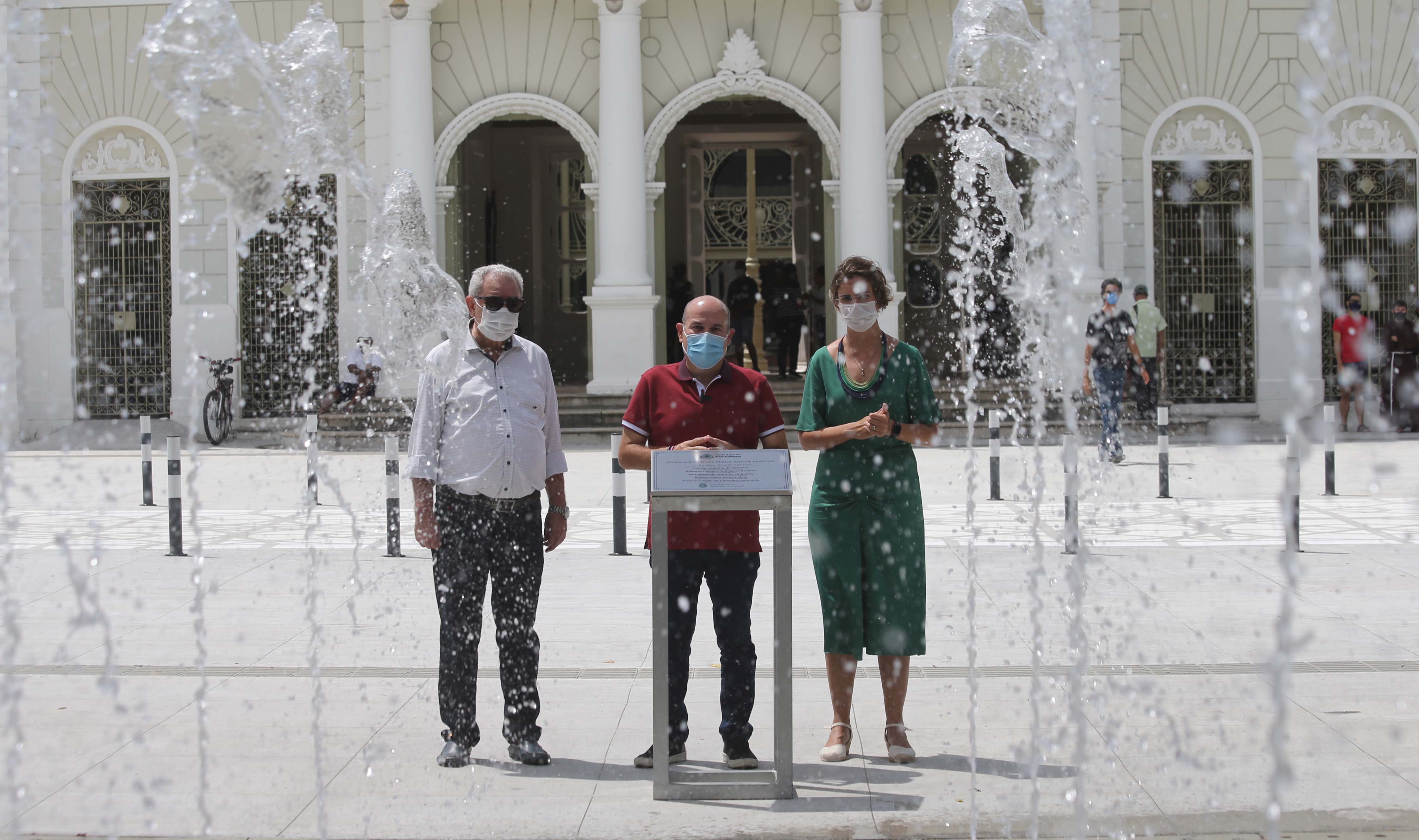 três pessoas com máscara na frente do Theatro José de Alencar